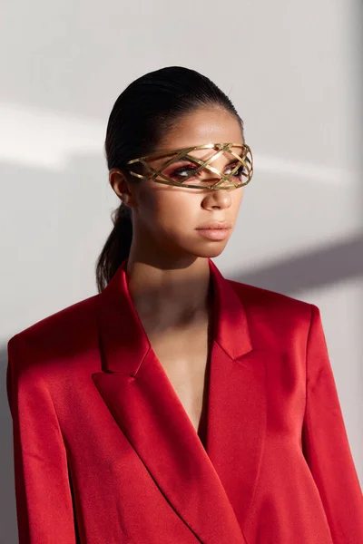 Retrato de una mujer en una chaqueta roja con un adorno de hierro en su cabeza estilo de moda de fondo claro — Foto de Stock