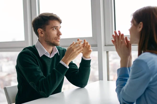 Mann und Frau sitzen an einem Tisch in der Nähe des Fensters in einem hellen Raum abgeschnittene Ansicht — Stockfoto