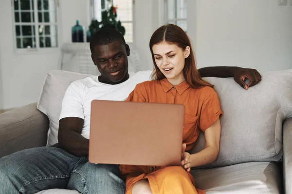 Femme et homme avec ordinateur portable assis sur canapé amis famille — Photo