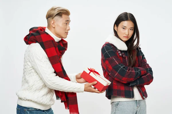 Asiatique homme donne un cadeau à une femme offensée sur un fond clair amis — Photo