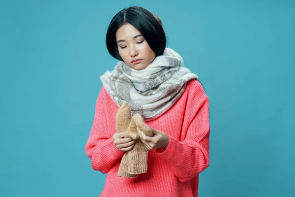 暖かいセーターのスカーフでアジアの女性とミトンオン青の背景クロップドビュー — ストック写真