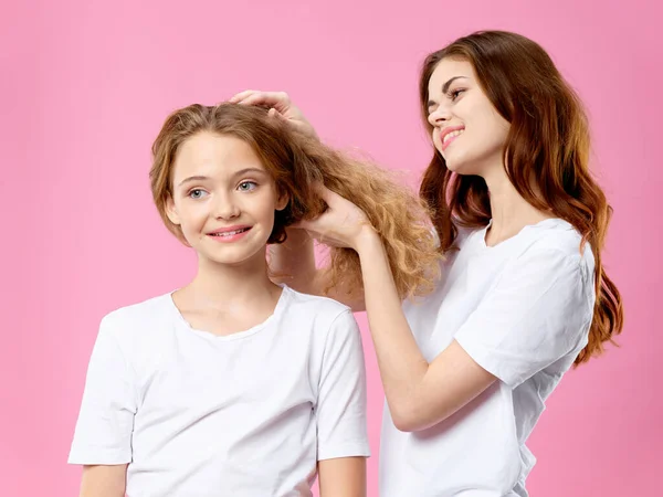 Мама и дочь в футболках Уход за волосами семьи розовый фон — стоковое фото