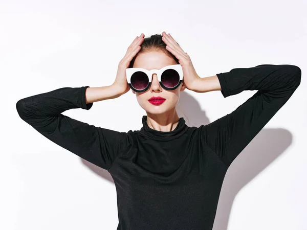 Žena modelka v černém svetru a sluneční brýle drží ruce na hlavě — Stock fotografie