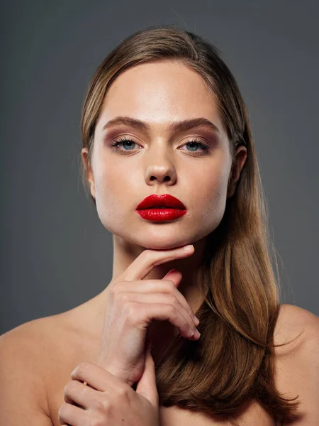 Retrato de una hermosa mujer con labios rojos sobre un modelo de fondo gris — Foto de Stock