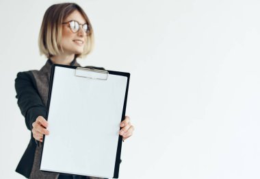 Resmi takım elbiseli bir kadın elinde beyaz bir kağıt tutuyor. Boşluğu kopyala.