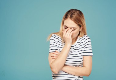 Üzgün kadın ellerini mavi arka plan yakın plan fotokopisi ile yüzüne dokunduruyor.