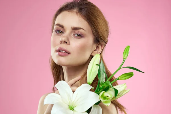 Hermosa mujer con flores en el modelo de retrato de maquillaje de fondo rosa — Foto de Stock