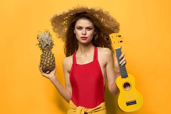 Kvinna som håller Ukulele halm hatt livsstil Exotisk gul bakgrund — Stockfoto