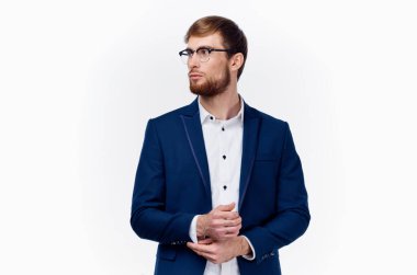 Mavi ceketli, gözlüklü, açık renk gömlekli bir iş adamı.