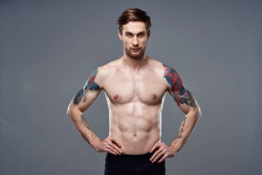 Sportif adam gaza geldi. Basın, kollarıyla hareket ediyor. Gri arka plan.