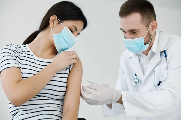 Man läkare som ger en spruta i axeln hälsa injektion närbild covid vaccination — Stockfoto
