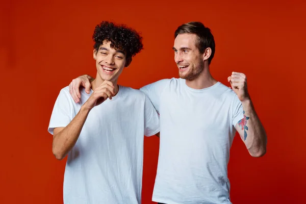 Два весёлых друга в белых футболках общаются — стоковое фото