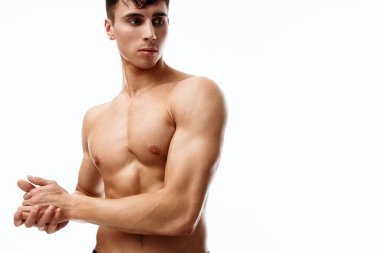 Kolları şişmiş erkek model yan tarafa bakıyor. 