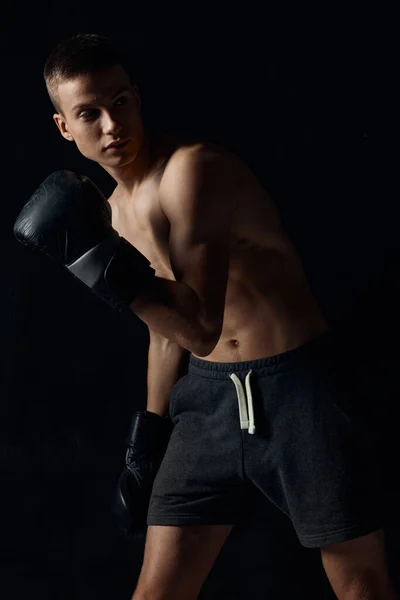 Боксер нахилився вперед на чорному тлі з рукавичками обрізаний вид — стокове фото
