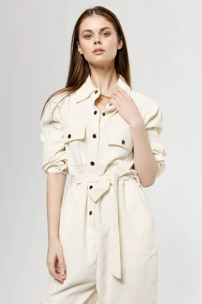Красива леді в білому комбінезоні на світлому тлі модна модель стилю одягу — стокове фото