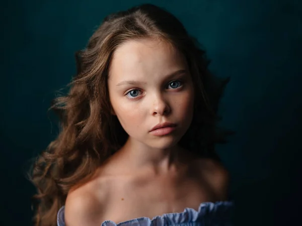 Портрет красивой маленькой девочки в сарафане на тёмном фоне крупным планом — стоковое фото