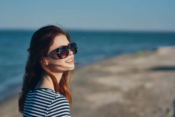 Kobieta w okularach i w paski T-shirt o zachodzie słońca lub tam w pobliżu morza widok z balkonu — Zdjęcie stockowe