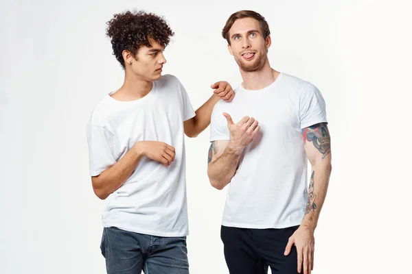 하얀 티셔츠를 입은 두 명의 쾌활 한 친구가 감정을 받아들인다 — 스톡 사진