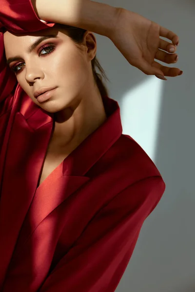 Mulher segurando mão perto de rosto moda posando casaco vermelho — Fotografia de Stock