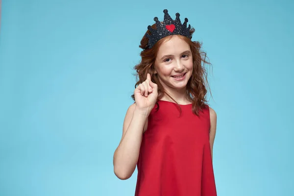 Dívka v červených šatech s kudrnaté vlasy zábava životní styl modré pozadí — Stock fotografie