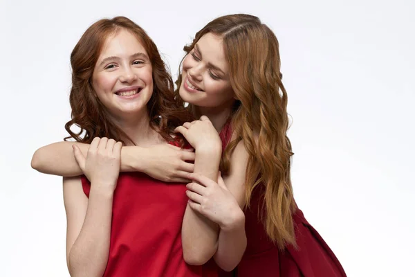 Mutter und Tochter rotes Kleid umarmen Familie Freude Freundschaft — Stockfoto