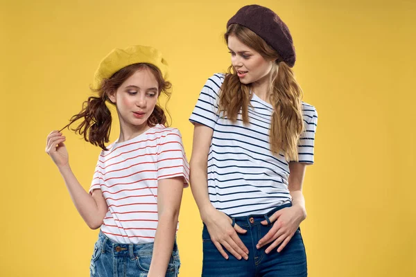 funny mom and daughter wearing hats fashion fun joy family yellow background