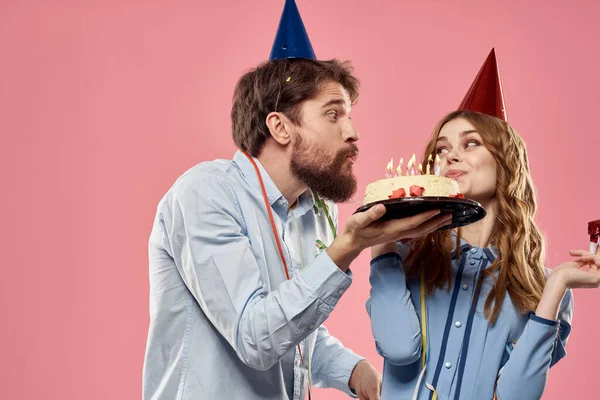Fête homme et femme avec gâteau sur fond rose anniversaire de l'entreprise — Photo