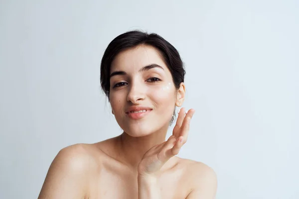 Красивая брюнетка чистый уход за кожей лица дерматологический крем — стоковое фото