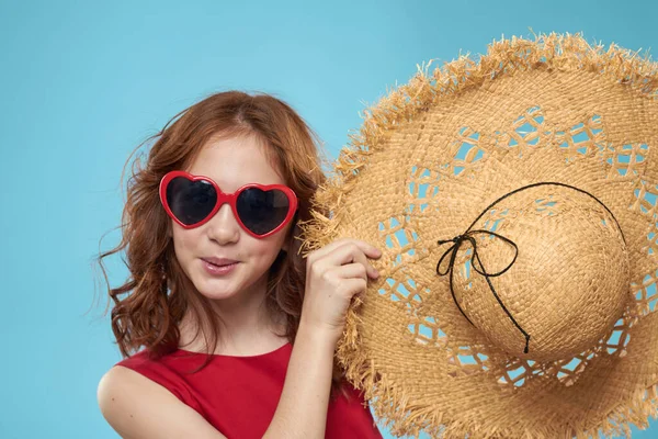 Menina em uma praia Chapéu de palha em óculos de sol cabelo encaracolado divertido fundo azul — Fotografia de Stock