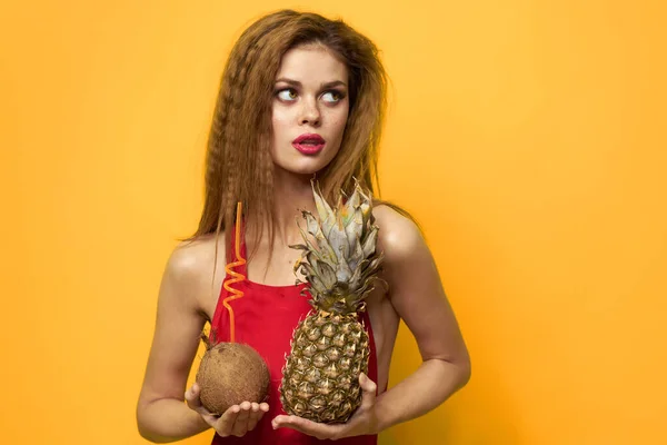 Kvinna med ananas och kokos cocktail exotiska frukter sommar livsstil gul bakgrund — Stockfoto