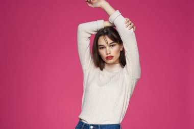 Güzel esmer, uzun saçlı, şık, zarif, pembe arka planlı.