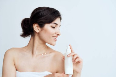 Kadın havlu öldürdü. Losyon, çıplak omuzlar. Temiz cilt, sağlıklı cilt.