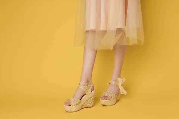 Donna in abito gambe scarpe attraente sguardo giallo sfondo moda — Foto Stock