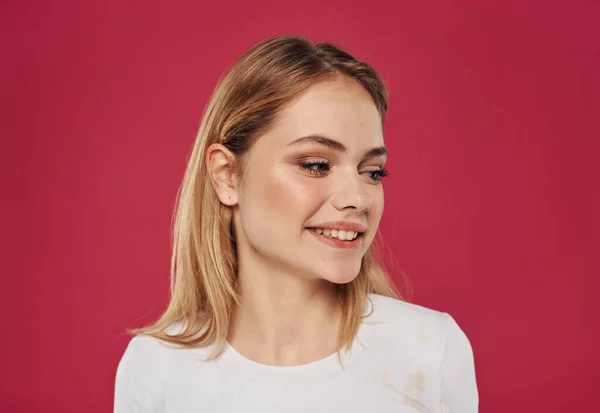 Retrato de una hermosa mujer sobre un fondo rojo rubia en una camiseta emociones modelo —  Fotos de Stock