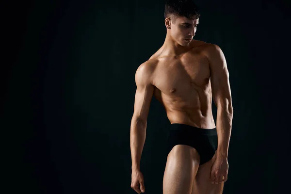 Σέξι αρσενικό bodybuilder σε σκούρο εσώρουχο θέτοντας στούντιο — Φωτογραφία Αρχείου