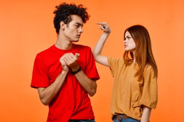 Neşeli genç çift yaşam tarzı stüdyo turuncu arka plan kırpılmış manzara