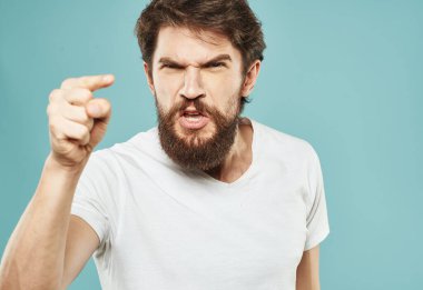 Beyaz tişörtlü ve kalın sakallı duygusal bir adamın portresi.