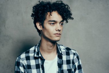 Neşeli adam kıvırcık saçlı ve ekose gömlekli modern tarz stüdyo modeli.