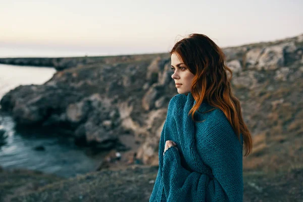 山の海の近くの日没時に毛布を肩にかけている女性です 高品質の写真 — ストック写真