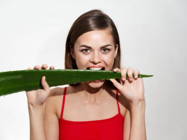 Kadın portresi, pürüzsüz cilt kozmetolojisi, kırmızı tişört, kırpık manzara.