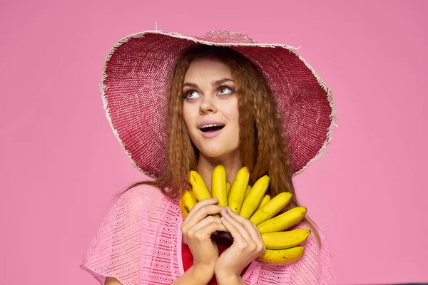 Λαμπερό γυναίκα με μπανάνες εξωτικά φρούτα καλοκαίρι ροζ φόντο — Φωτογραφία Αρχείου