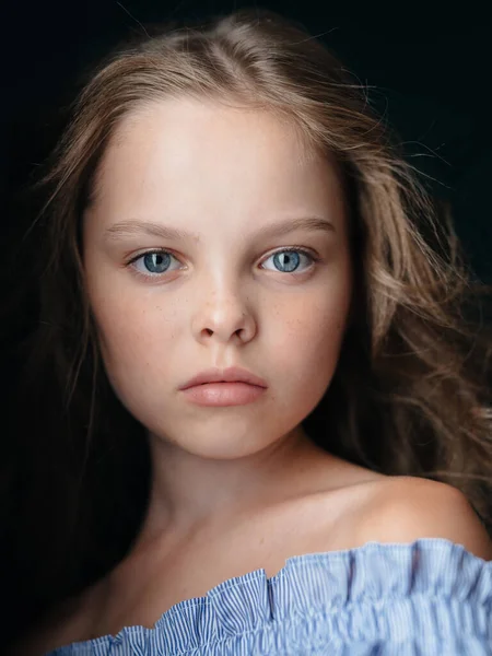 Портрет красивої маленької дівчинки на темному тлі в сараї, голі плечі — стокове фото