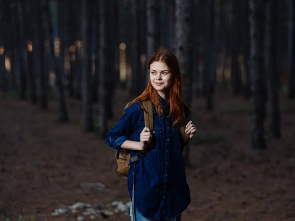 Žena turistka procházka v lese v blízkosti borovic v přírodě — Stock fotografie