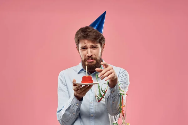 День рождения человека с тортом и свечой на розовом фоне — стоковое фото