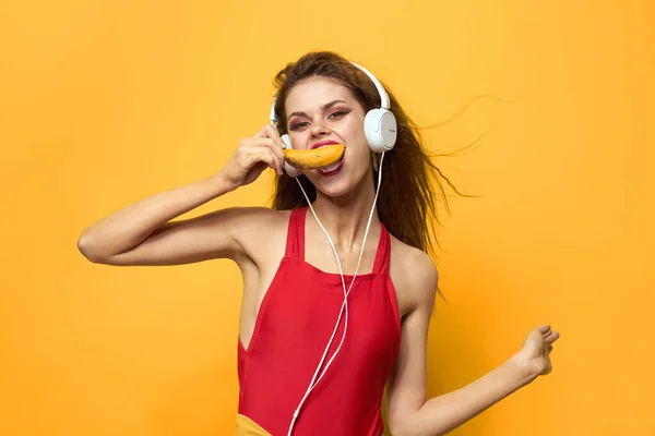 Femme émotionnelle dans les écouteurs blancs écoute de la musique fun style de vie fond jaune — Photo