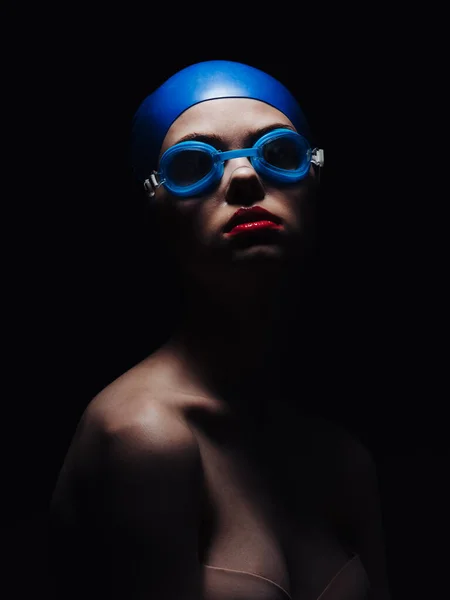 Beautiful woman in goggles for swimming and bright makeup red lips black background — Stock Photo, Image