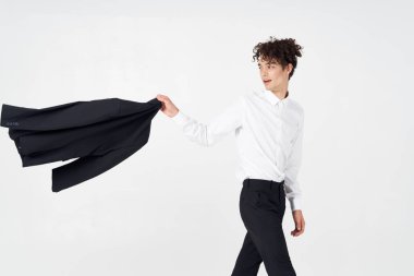  Gömlekli ve pantolonlu bir adam elinde ceket, arka planda kırpılmış bir model.