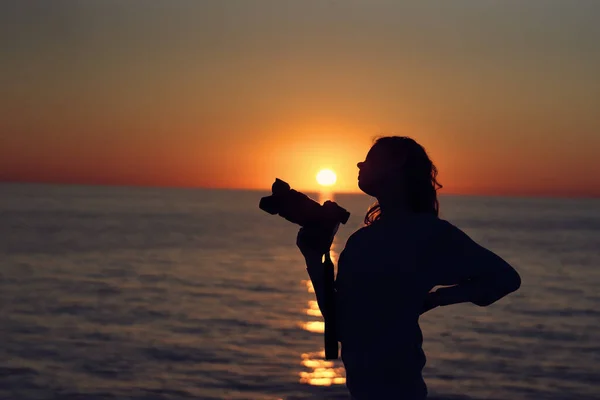 해 가 지는 곳 근처에서 카메라를 든 여자의 실루엣 사진 — 스톡 사진