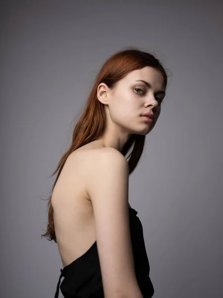 Portrait d'une belle femme aux cheveux roux aux épaules nues sur fond gris gros plan — Photo