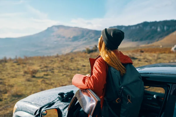 Viajero con una mochila cerca del coche en las montañas en verano y el cielo azul aire fresco — Foto de Stock